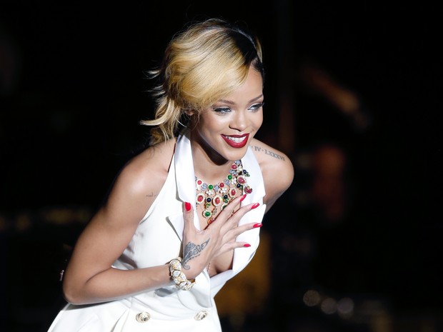 Rihanna usa vestido decotado e quase mostra demais em show
