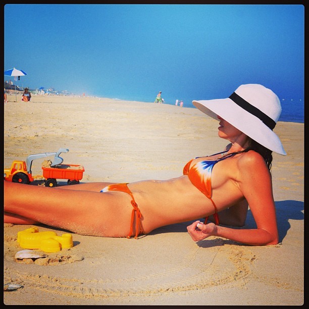 Com biquni de lacinho, Luciana Gimenez  clicada em dia de praia