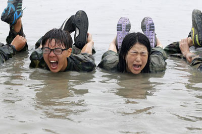 Estudantes coreanos fazem cara de dor durante acampamento militar