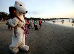 Vestido de urso polar, faz protesto na praia