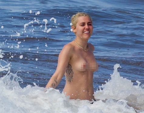 Miley Cyrus diverte-se em topless na praia no Hawaii
