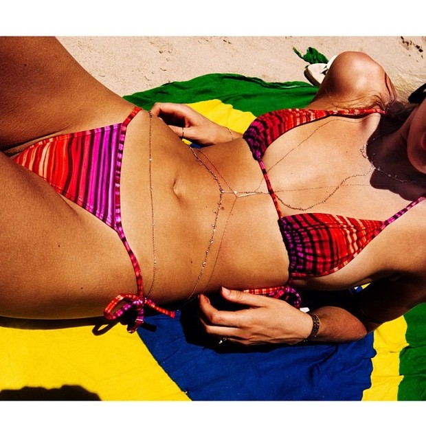 Candice Swanepoel curte praia em canga com a bandeira do Brasil