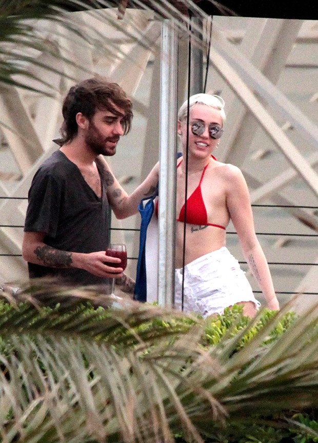 De biquni, Miley troca carinhos com homem misterioso em Barcelona