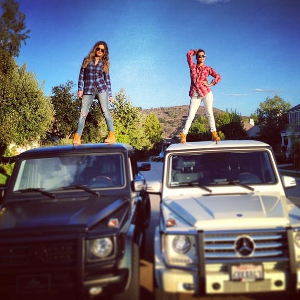 Kourtney e Khlo Kardashian posam em cima de carros
