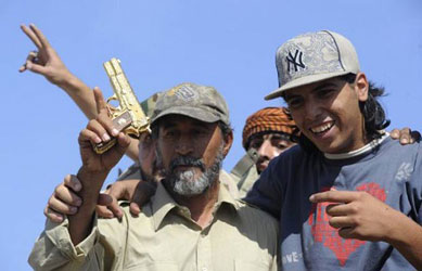 Combatente lbio comemora com pistola de ouro captura de Kadhafi